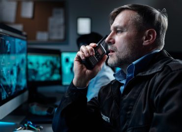Mature,Male,Security,Guard,With,Walkie-talkie,By,Mouth,Reporting,Situation